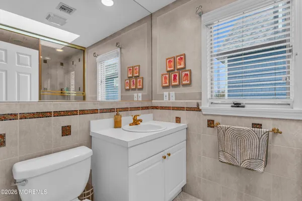 a bathroom with a toilet sink and mirror