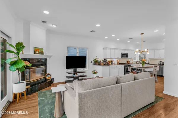 a living room with furniture a flat screen tv and kitchen view