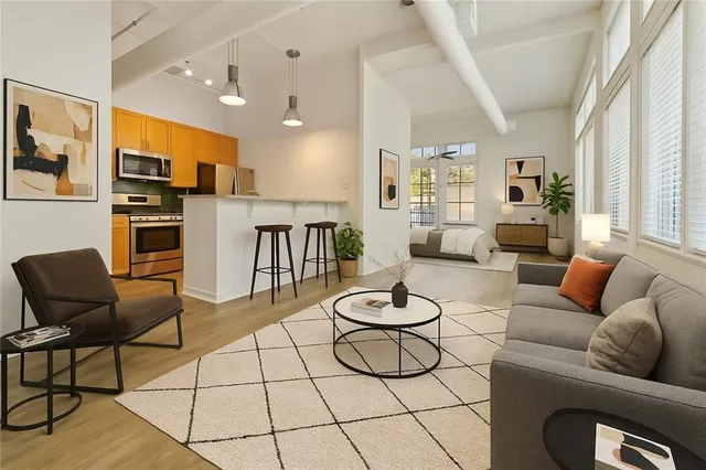 a living room with furniture a flat screen tv and kitchen view