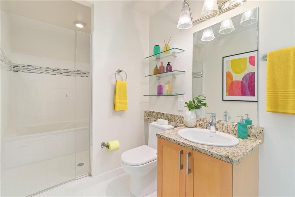 572 Edgewood Avenue Northeast, Unit 106 Atlanta, GA 30312 - Photo 5 of 17 a bathroom with a granite countertop sink a toilet and shower