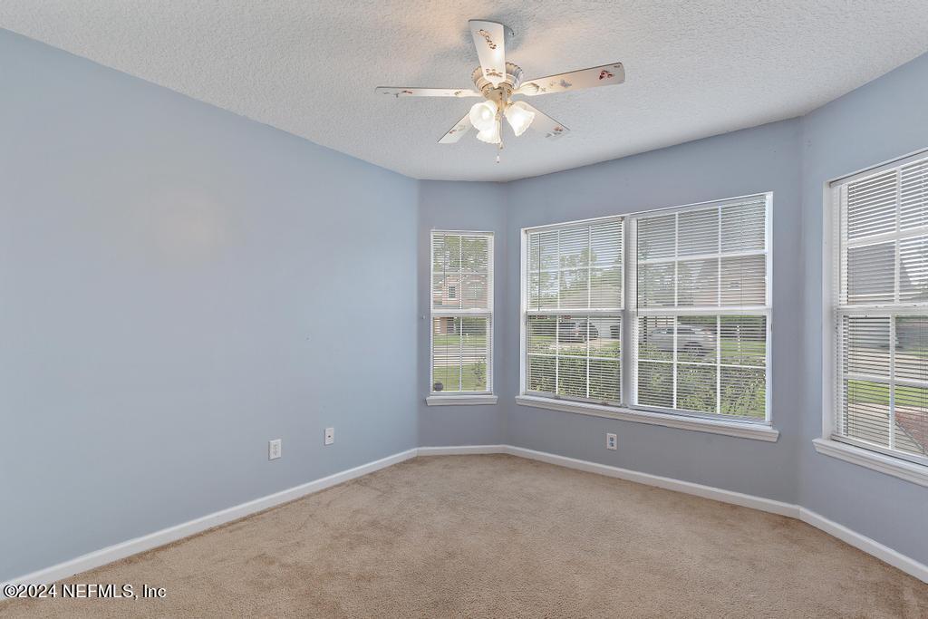 5902 Round Table Road Jacksonville, FL 32254 - Photo 15 of 44 an empty room with chandelier fan and windows