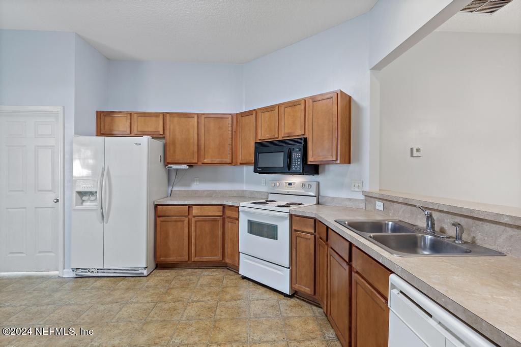 5902 Round Table Road Jacksonville, FL 32254 - Photo 7 of 44 a kitchen with stainless steel appliances granite countertop a sink stove and refrigerator