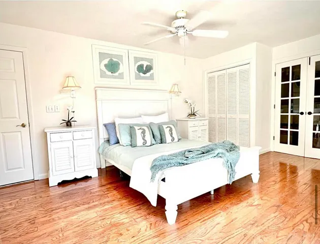 a large bedroom with a bed and wooden floor