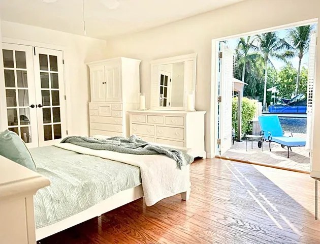 a bedroom with a bed and a large window with outer view