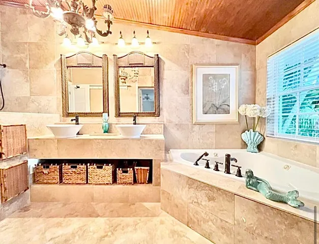 a large bathroom with a tub sink and mirror