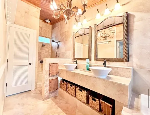 a bathroom with a granite countertop sink a mirror and next to a window