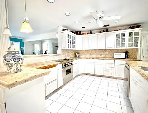 a large kitchen with granite countertop a sink and cabinets