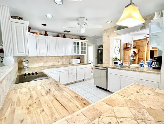 a large kitchen with kitchen island a sink a stove top oven a chimney and a center island