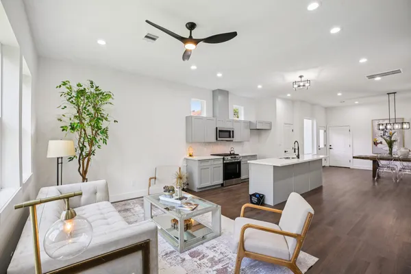 a living room with furniture kitchen and a potted plant