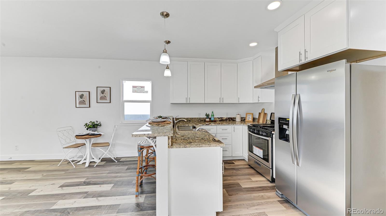 660 Meade Street Denver, CO 80204 - Photo 11 of 25 a kitchen with stainless steel appliances kitchen island granite countertop a refrigerator and a stove top oven