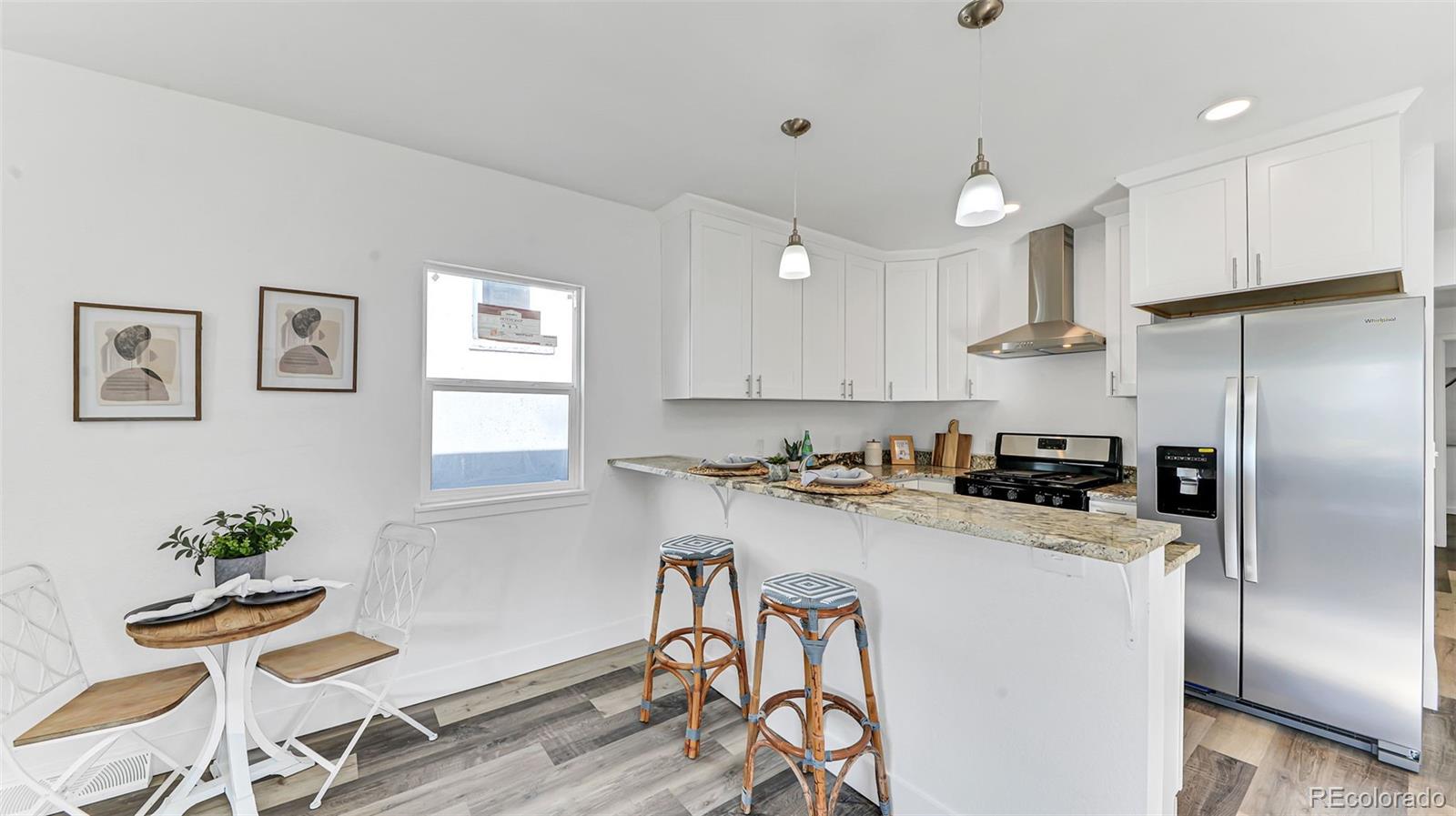 660 Meade Street Denver, CO 80204 - Photo 13 of 25 a kitchen with a refrigerator a stove a dining table and chairs with wooden floor