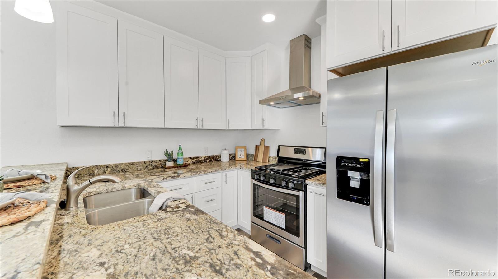660 Meade Street Denver, CO 80204 - Photo 14 of 25 a kitchen with stainless steel appliances granite countertop a sink a stove and a refrigerator