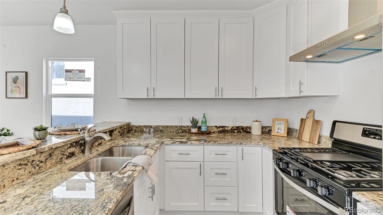 660 Meade Street Denver, CO 80204 - Photo 15 of 25 a kitchen with granite countertop a sink a stove and cabinets