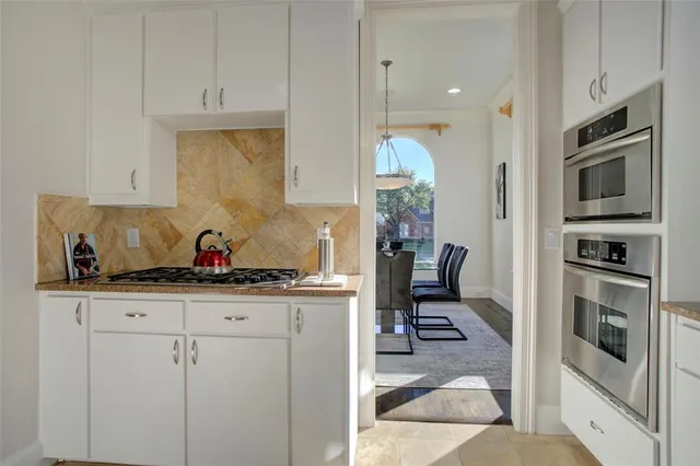 a kitchen with granite countertop a sink stainless steel appliances and cabinets