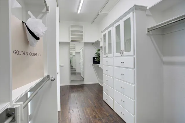 a hallway with white cabinets and wooden floor