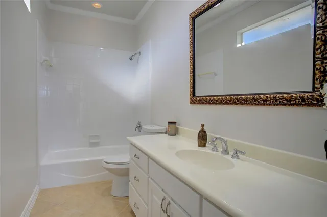 a bathroom with a granite countertop sink a toilet and shower