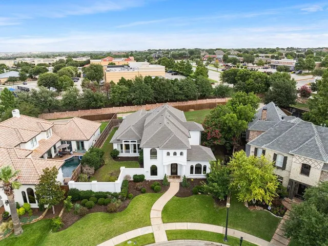 an aerial view of residential houses with outdoor space and trees