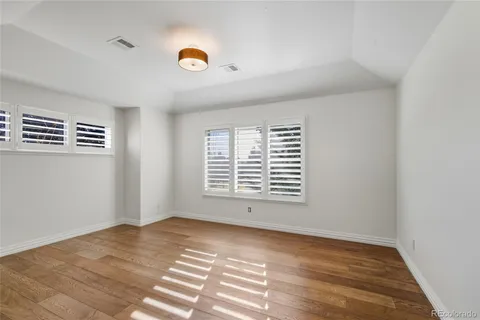a view of an empty room with kitchen and a window