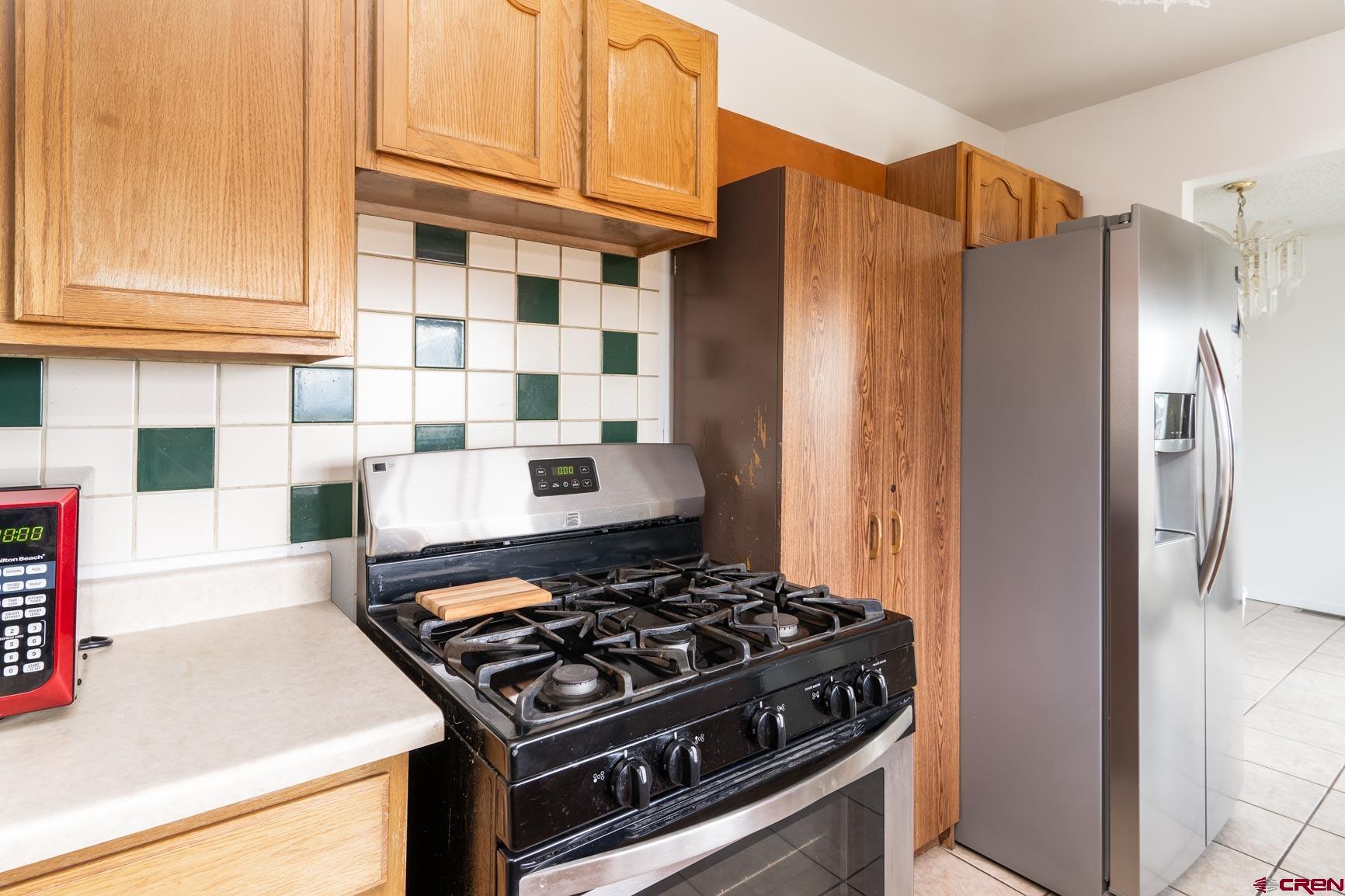4 North Dolores Road Cortez, CO 81321 - Photo 18 of 24 a kitchen with stainless steel appliances granite countertop a stove and a refrigerator with cabinets