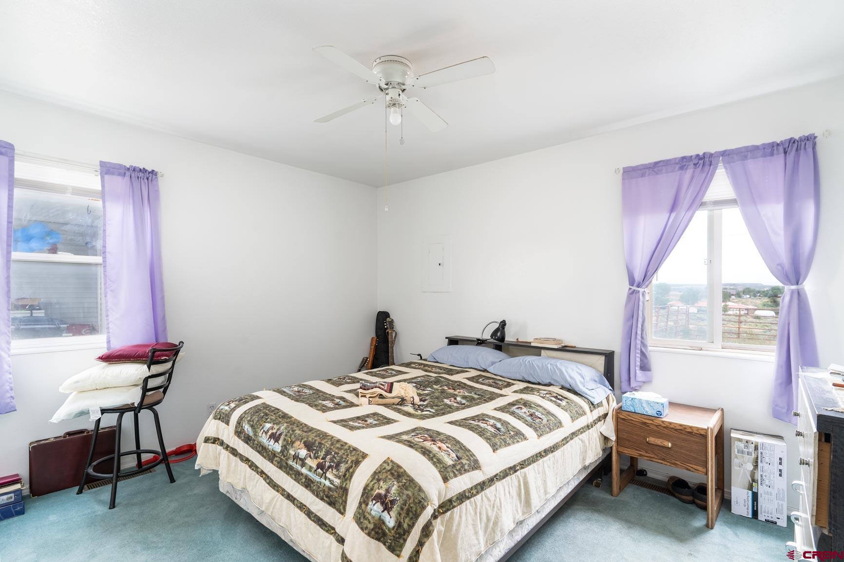 4 North Dolores Road Cortez, CO 81321 - Photo 3 of 24 a bedroom with a bed a chandelier and a window