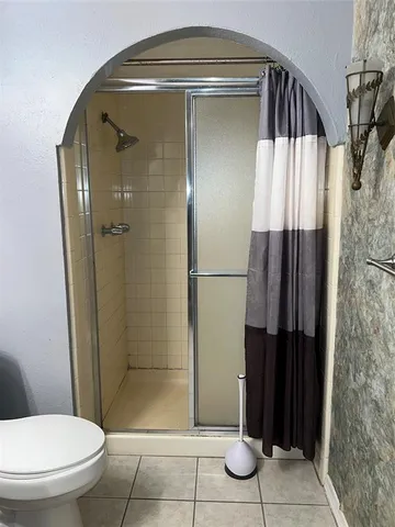 a bathroom with a toilet and a glass door