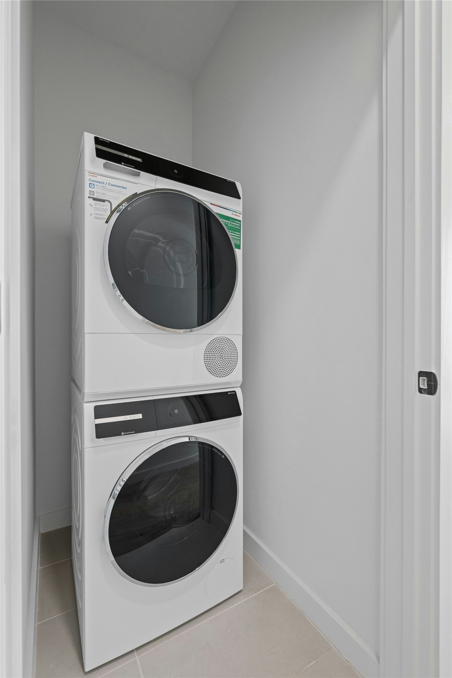 2209 South 1st Street, Unit 321 Austin, TX 78704 - Photo 25 of 40 Laundry room with stacked washing machine and dryer and light tile patterned floors