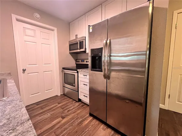 a kitchen with a refrigerator sink and cabinets