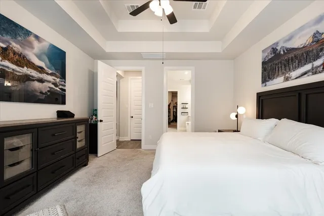 a bedroom with a bed and a flat tv screen on dresser