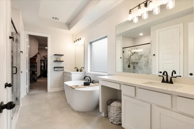 a bathroom with a double vanity sink mirror and bathtub