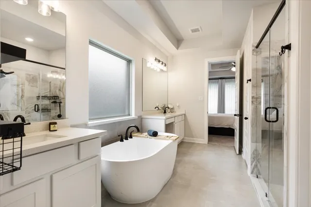 a bathroom with a tub sink shower and mirror