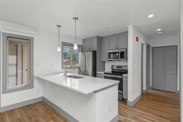 a kitchen with stainless steel appliances granite countertop a refrigerator a sink and a stove