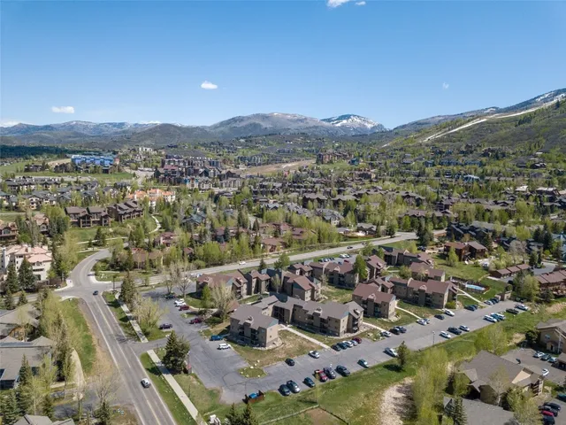 an aerial view of a city with lots of residential buildings and mountain view in back