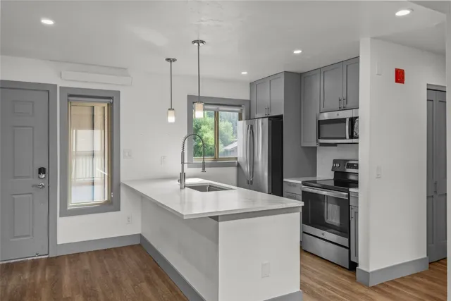 a kitchen that has a sink stainless steel appliances a counter space and a window
