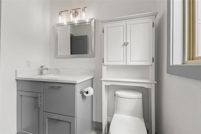 a bathroom with a sink a toilet and a window