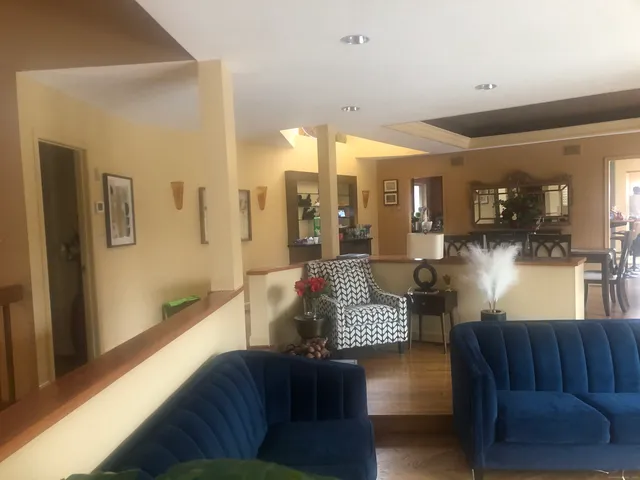 a living room with couches and a view of kitchen