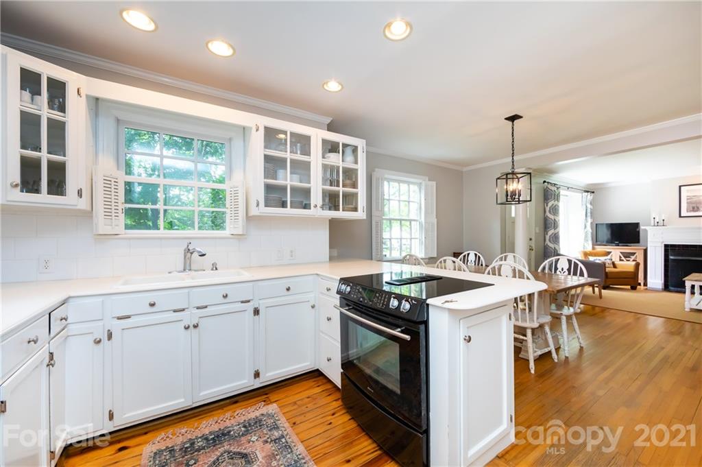 816 Sedgefield Road Charlotte, NC 28209 - Photo 11 of 29 a kitchen that has a sink a stove and a wooden floor