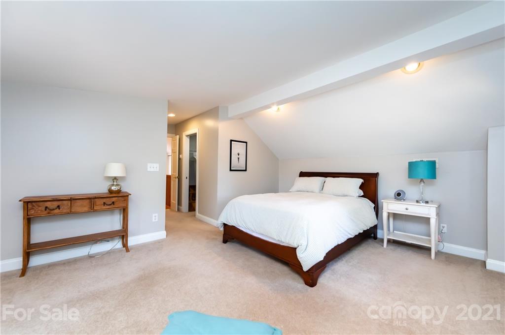 816 Sedgefield Road Charlotte, NC 28209 - Photo 16 of 29 a spacious bedroom with a bed and a lamp