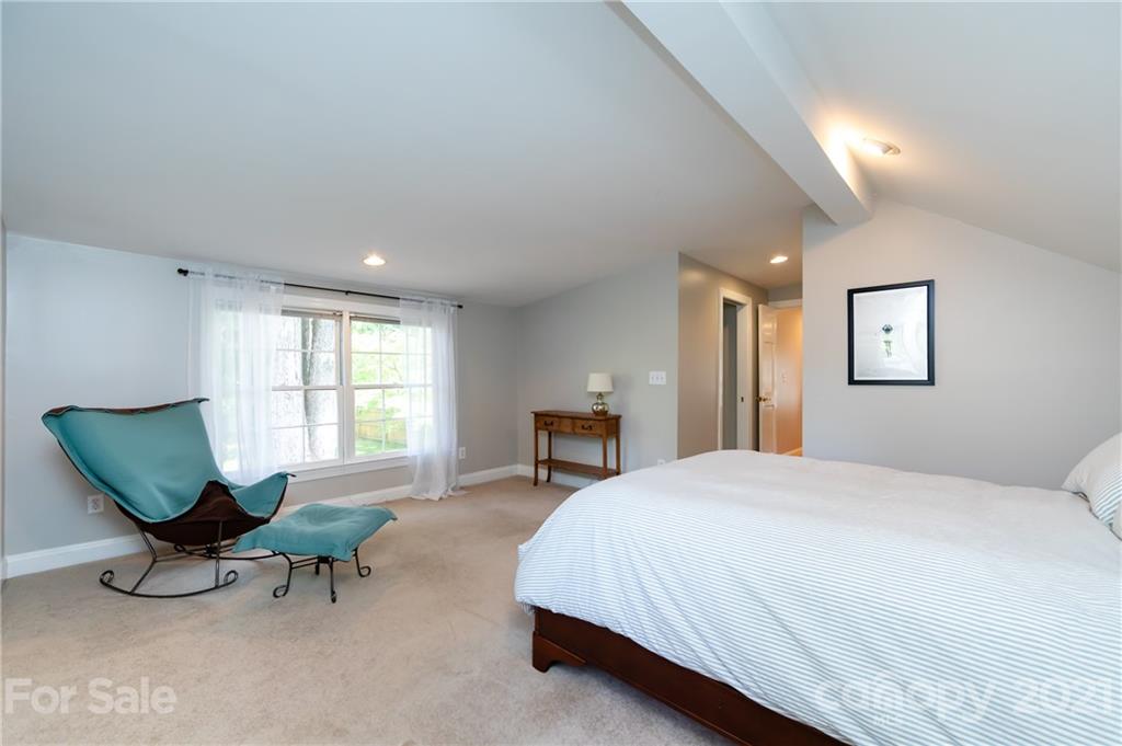 816 Sedgefield Road Charlotte, NC 28209 - Photo 17 of 29 a spacious bedroom with a bed and a chair