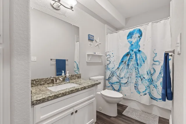 a bathroom with a granite countertop toilet sink and shower