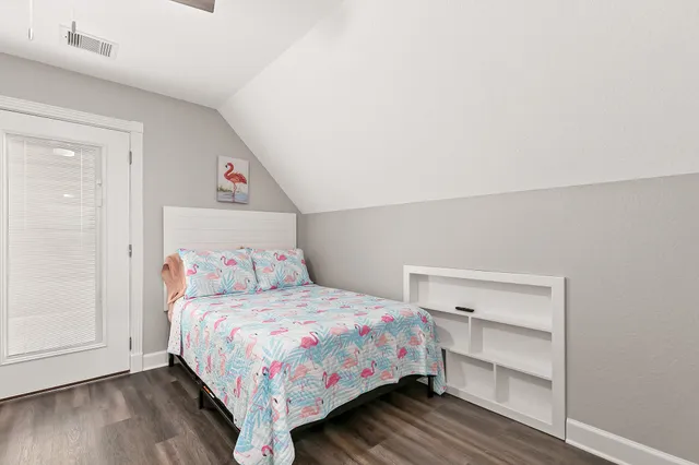 a bedroom with a bed and wooden floor