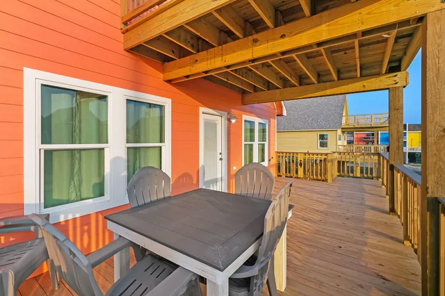 a view of a patio with table and chairs with wooden floor and fence