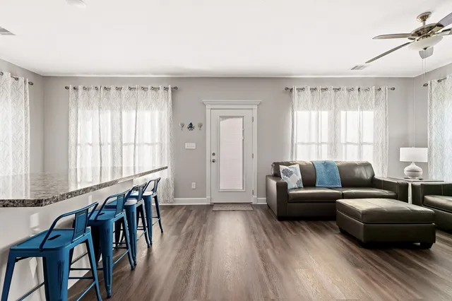 a living room with furniture and a wooden floor