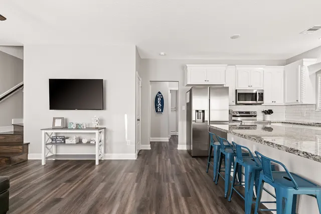a view of kitchen with sink microwave refrigerator and cabinets