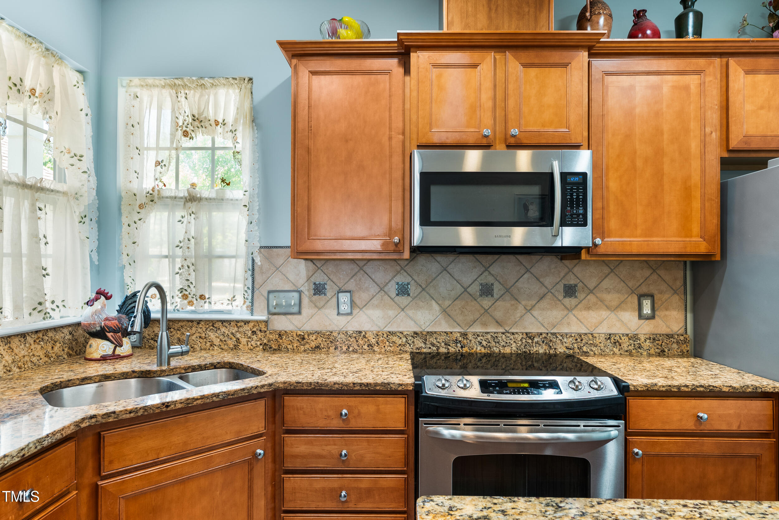 575 Tomkins Loop Cary, NC 27519 - Photo 11 of 44 a kitchen with granite countertop a stove a microwave a sink and cabinets