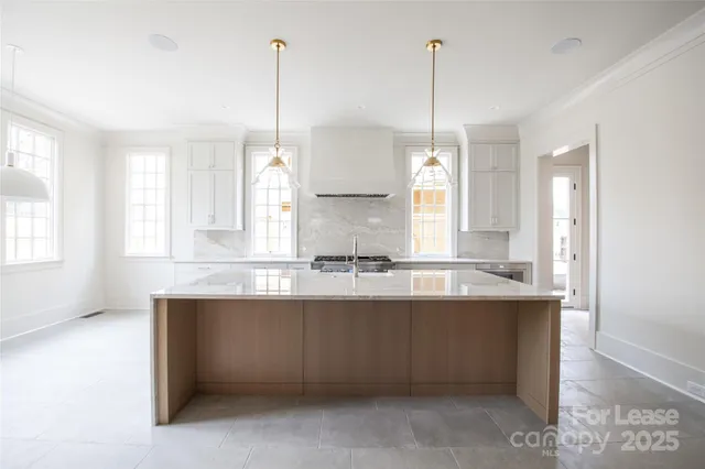 a kitchen with granite countertop a sink and a stove top oven
