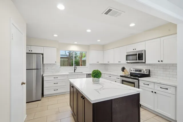 a kitchen with stainless steel appliances a stove refrigerator sink and microwave