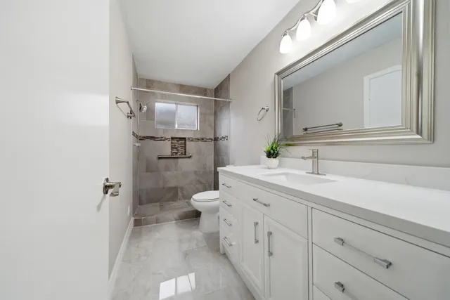 a bathroom with a sink a toilet and shower