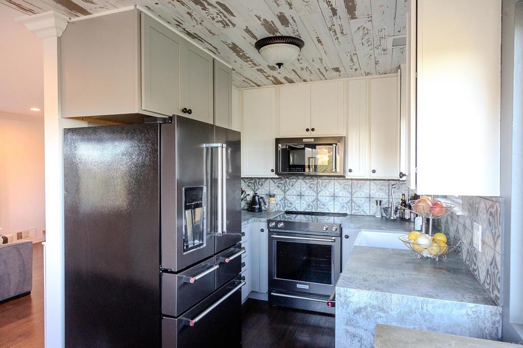 751 South Grade Road Alpine, CA 91901 - Photo 31 of 67 a kitchen with stainless steel appliances granite countertop a refrigerator a stove and a sink with wooden floor
