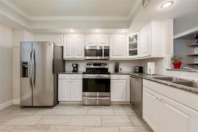 a kitchen with a refrigerator and a stove top oven