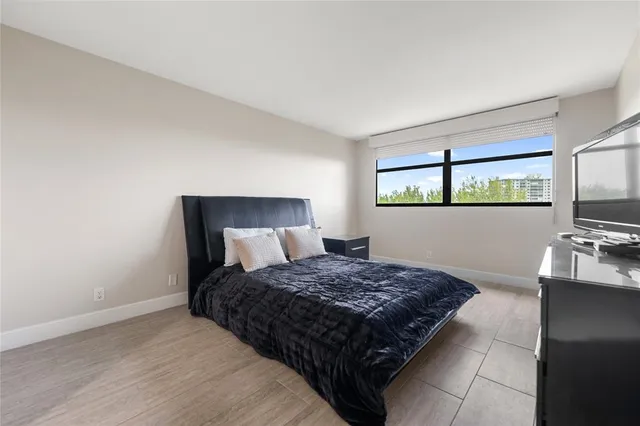 a bedroom with a large bed and a flat screen tv